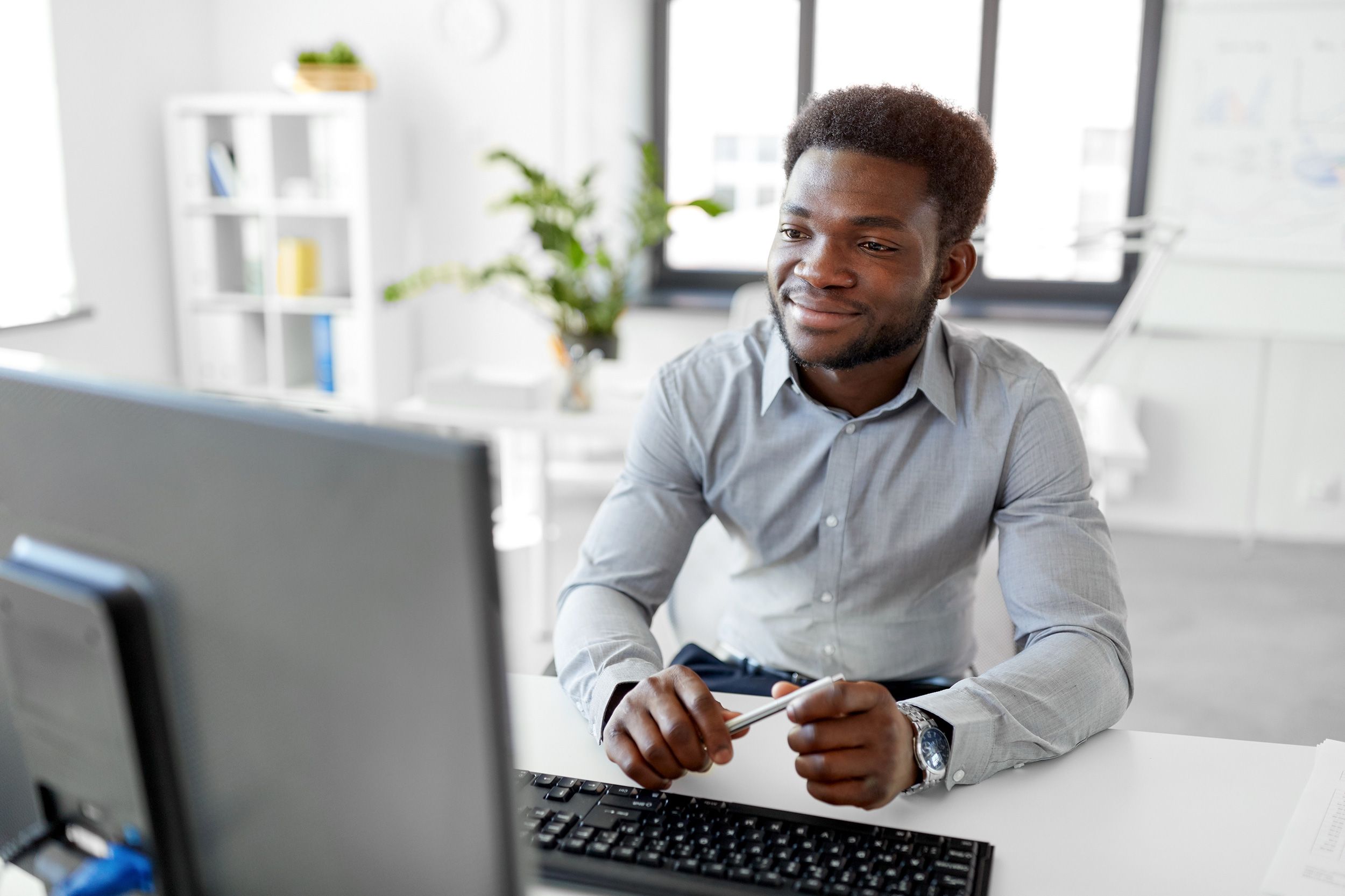 A younger man looking at his desktop computer