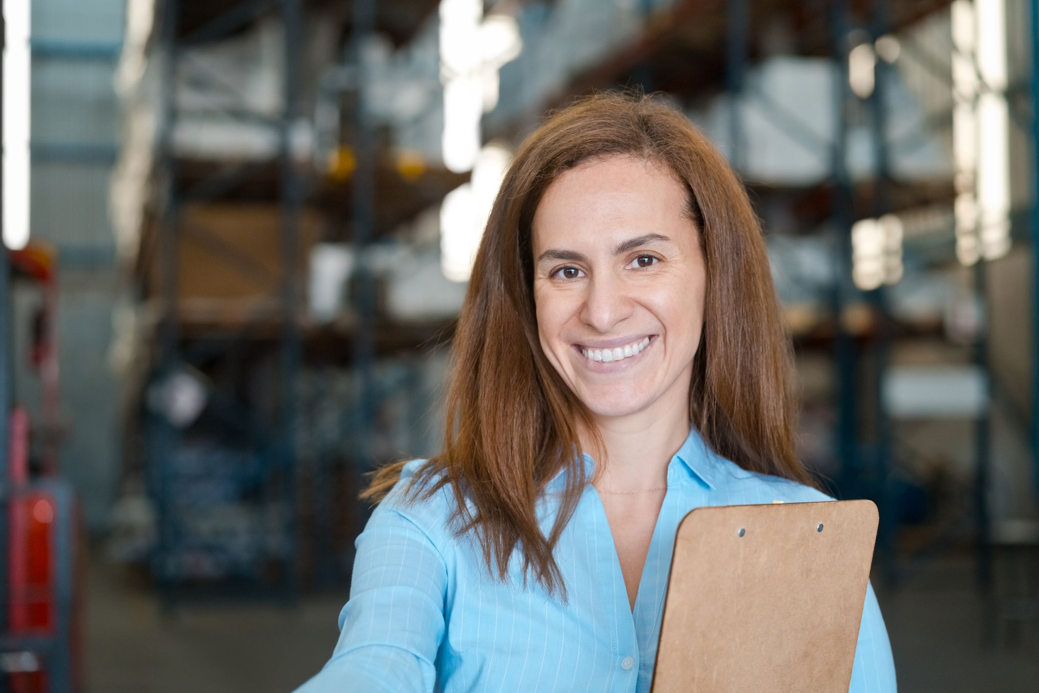 A woman holding a clipboard and smiling